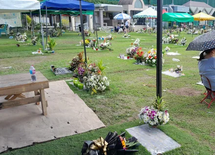 Familier med lys på gravlunden under Undas