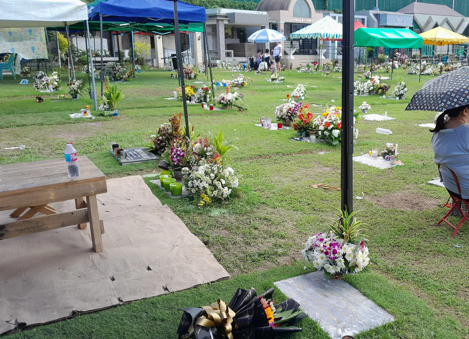 Familier med lys på gravlunden under Undas